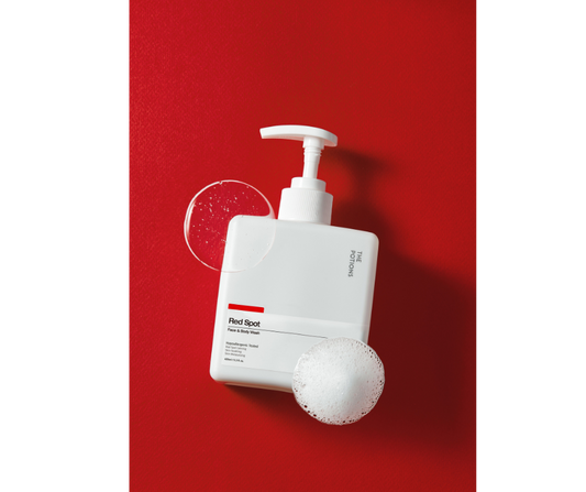 Produktbilde av Red Spot Akne Ansikt- og Kroppsvask med såpebobler på rød bakgrunn