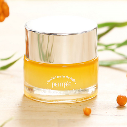 Bilde av Petitfee Oil Blossom Lip Mask Sea Buckthorn med to bær fra planten foran og stilken fra planten i bakgrunnen 